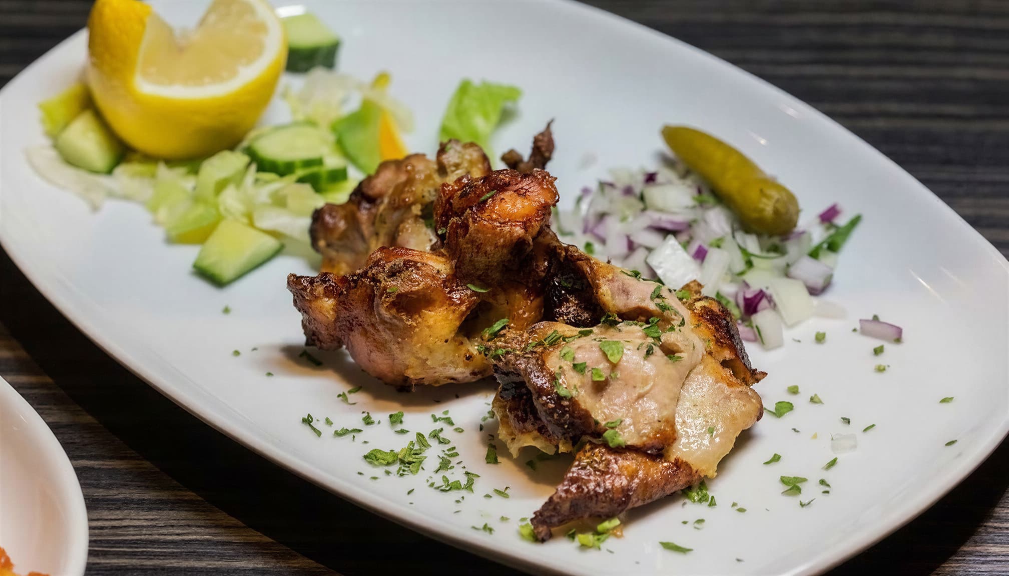 Charcoal-grilled Greek chicken with salad and lemon
